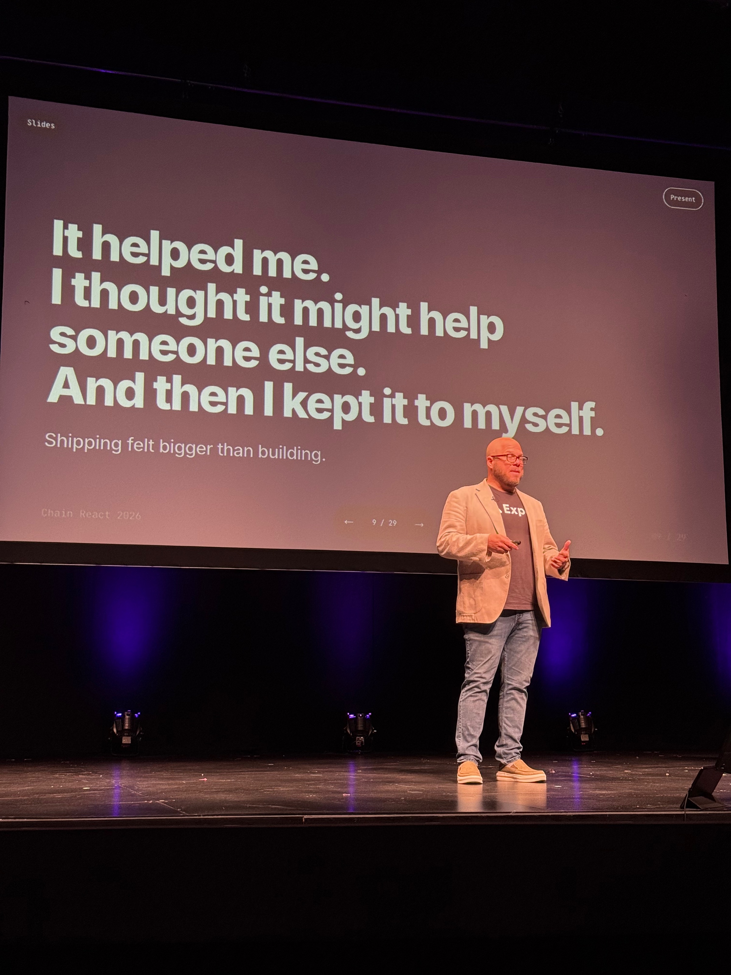 Seth on stage at Chain React 2026, in front of a slide reading "It helped me. I thought it might help someone else. And then I kept it to myself. Shipping felt bigger than building."